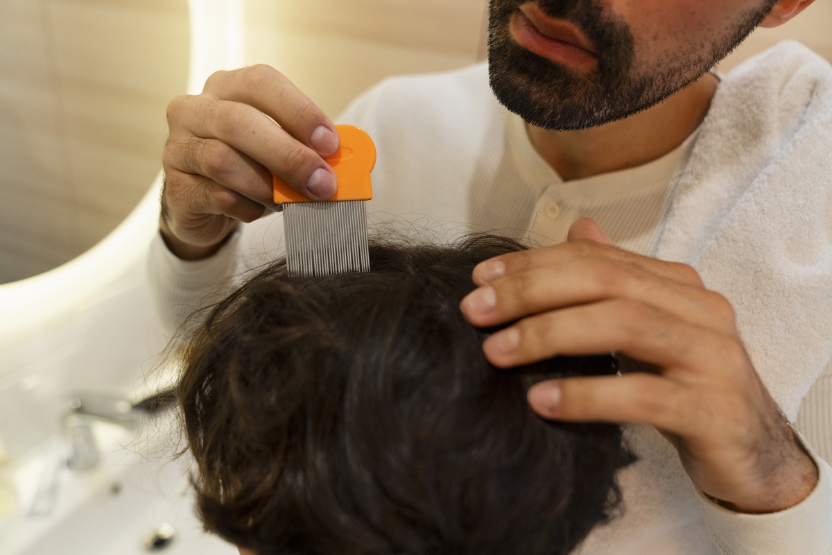 high-angle-father-holding-lice-comb